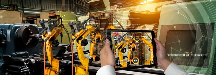 工程师通过扩大现实工业技术应用软件来控制机器人武未来工厂的智能